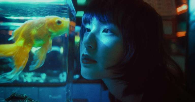 etnische-vrouw-die-vissen-in-aquarium-bekijkt