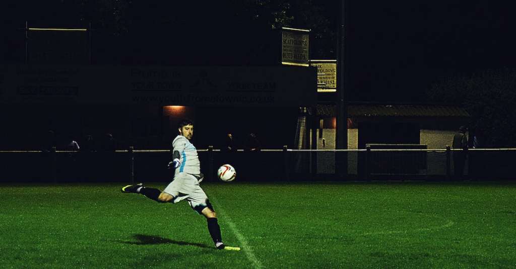 persoon-schopt-voetbal-in-veld