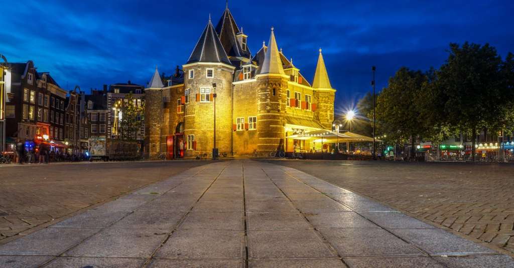 wit-en-grijs-kasteel-in-de-buurt-van-groene-bomen