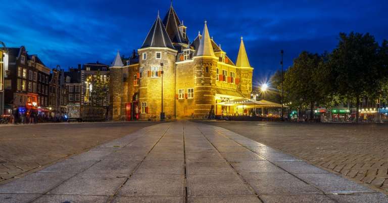 wit-en-grijs-kasteel-in-de-buurt-van-groene-bomen