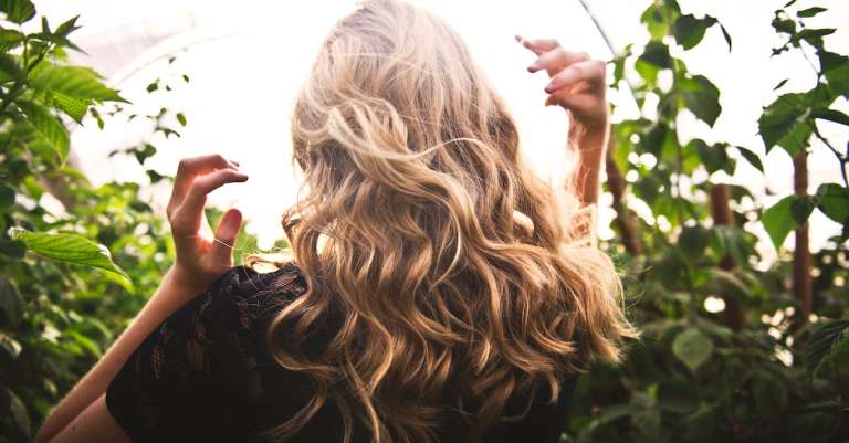 blondharige-vrouw-tussen-groene-planten