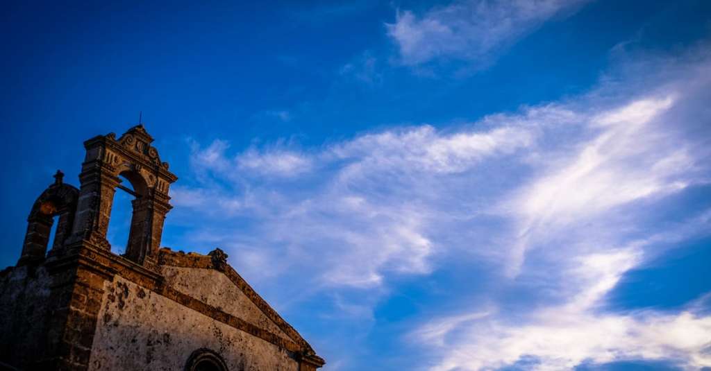 brown-concrete-kapel-onder-bewolkte-blauwe-hemel