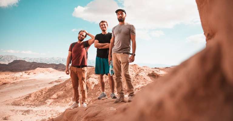 drie-mannen-staan-tegenover-witte-wolken