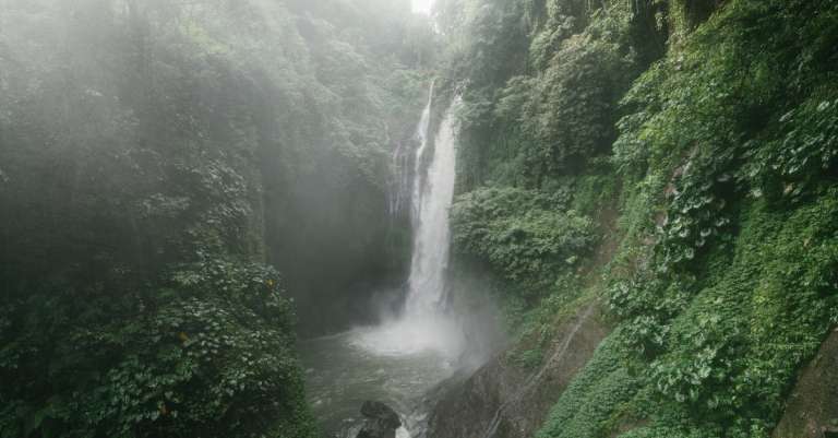 geweldige-waterval-met-weelderig-gebladerte-op-rotsen