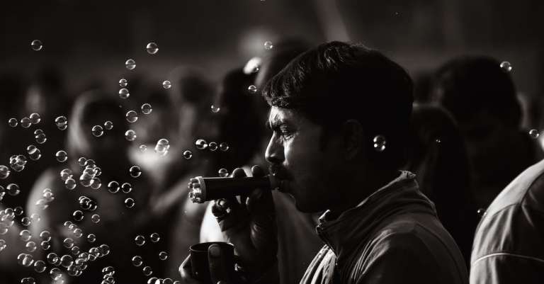 monochrome-foto-van-man-spelen-met-bubbels