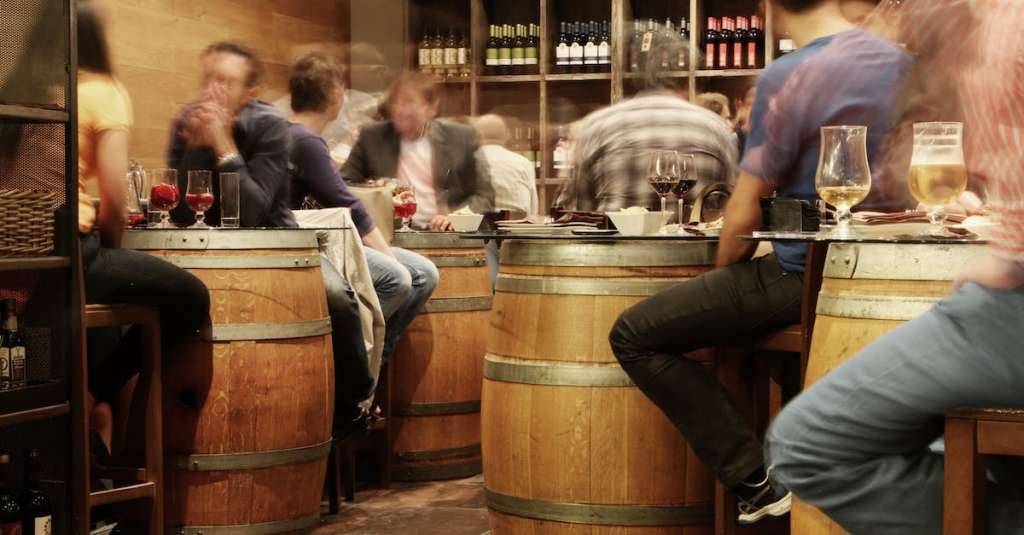 persoon-zit-in-de-buurt-van-de-bruine-houten-vat-tafel